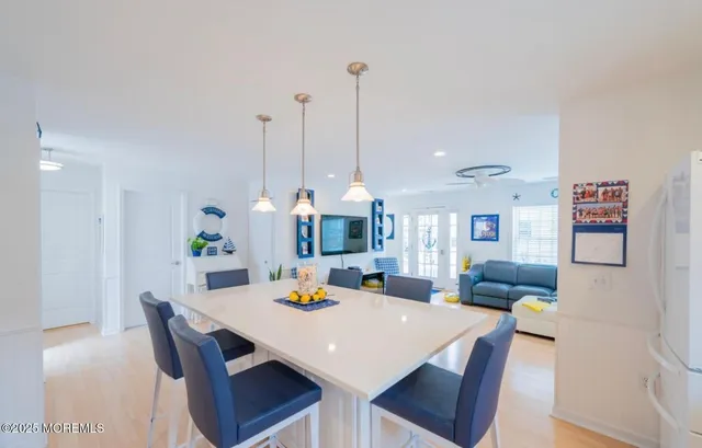 a view of a dining room and livingroom with furniture wooden floor a rug and a chandelier