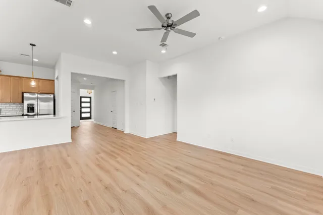 a view of an empty room and kitchen view