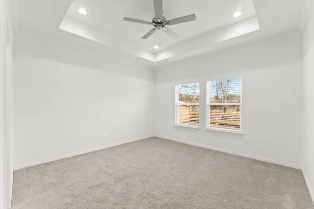 an empty room with a window and ceiling fan