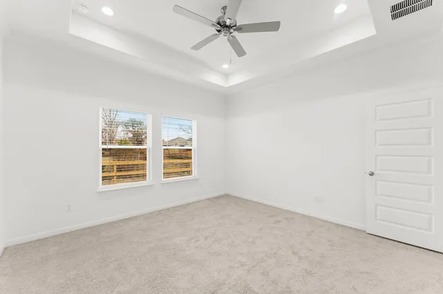 an empty room with a window and ceiling fan