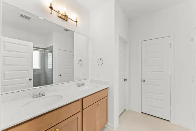 a spacious bathroom with a shower sink and mirror