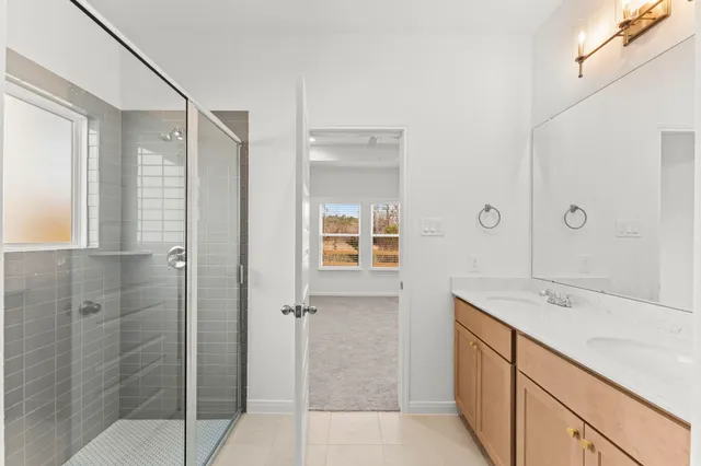 a bathroom with a shower sink and mirror