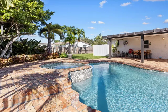 a swimming pool with outdoor seating and yard