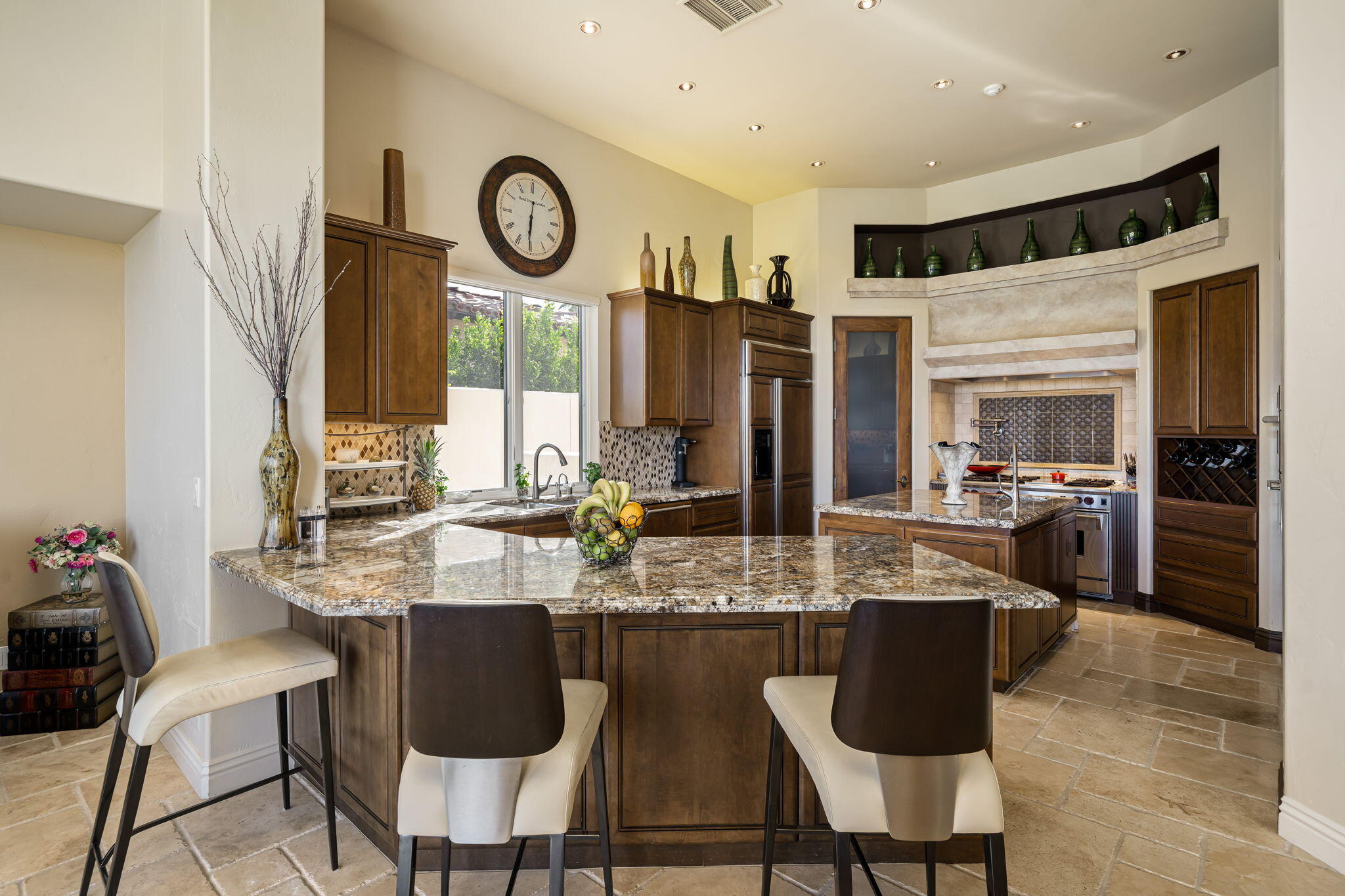 75836 Via Cortona Indian Wells, CA 92210 - Photo 33 of 113 a kitchen with stainless steel appliances granite countertop a stove a refrigerator a sink and chairs