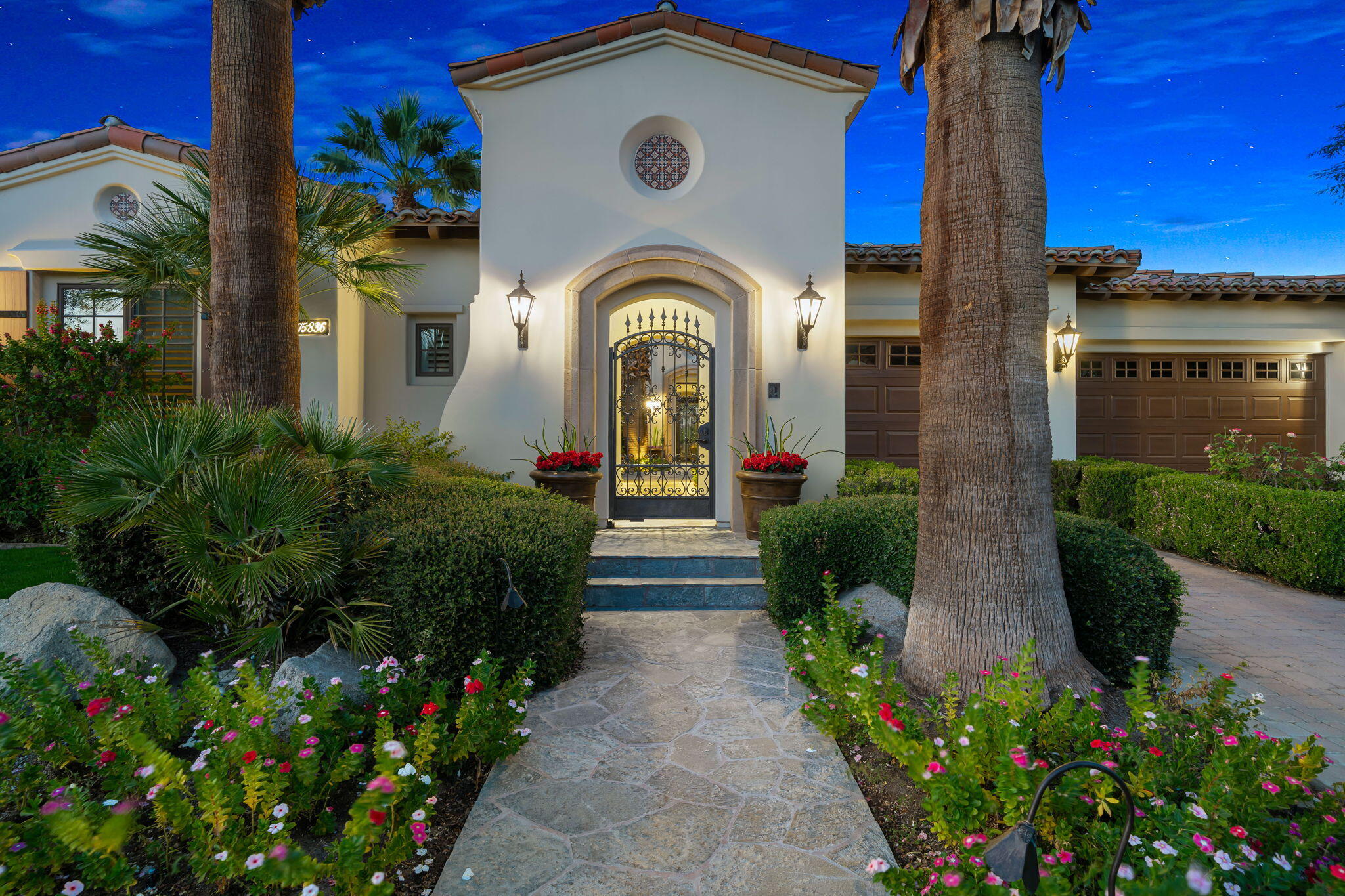 75836 Via Cortona Indian Wells, CA 92210 - Photo 92 of 113 a view of a house with large windows and flower plants