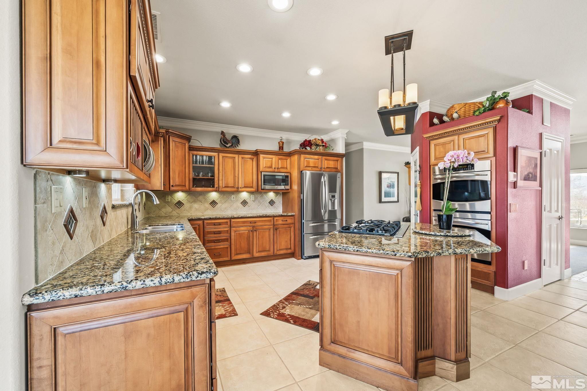 1335 Wolf Run Road Reno, NV 89511 - Photo 22 of 37 a kitchen with stainless steel appliances kitchen island granite countertop a stove and a sink
