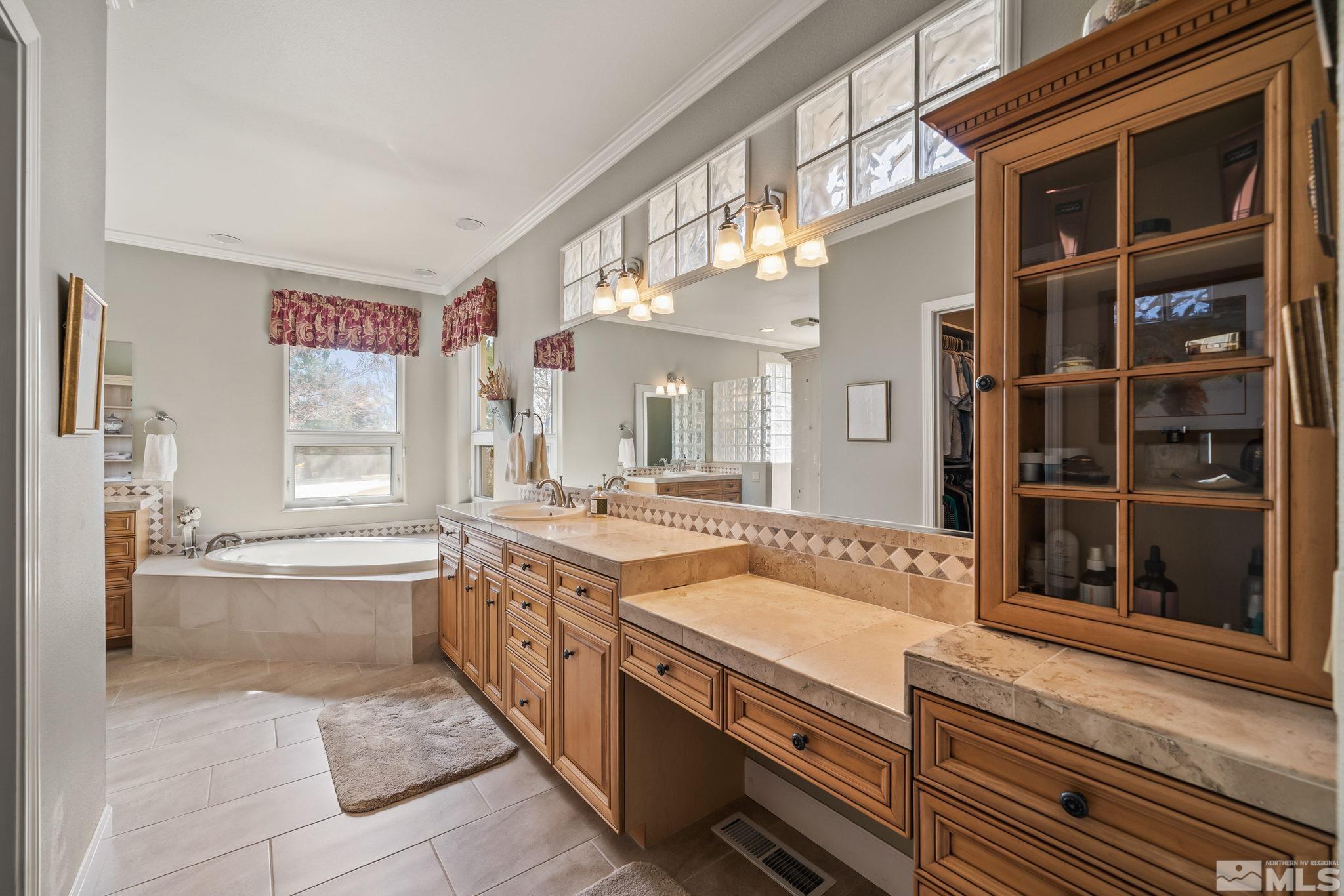 1335 Wolf Run Road Reno, NV 89511 - Photo 28 of 37 a spacious bathroom with a granite countertop tub that has a large mirror next to a window