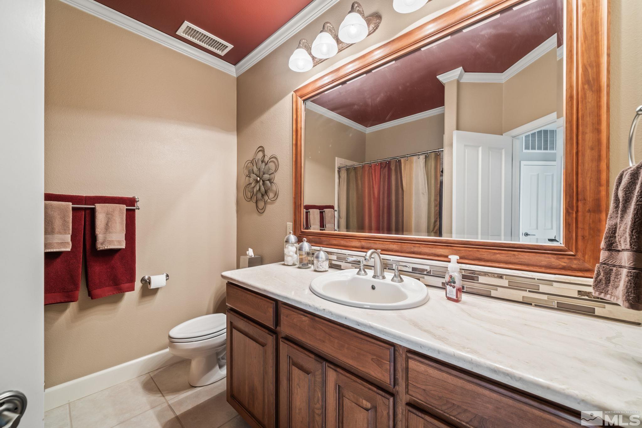 1335 Wolf Run Road Reno, NV 89511 - Photo 33 of 37 a bathroom with a sink a toilet a mirror and vanity