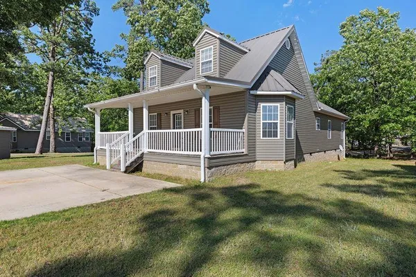 a view of a house with backyard and a tree