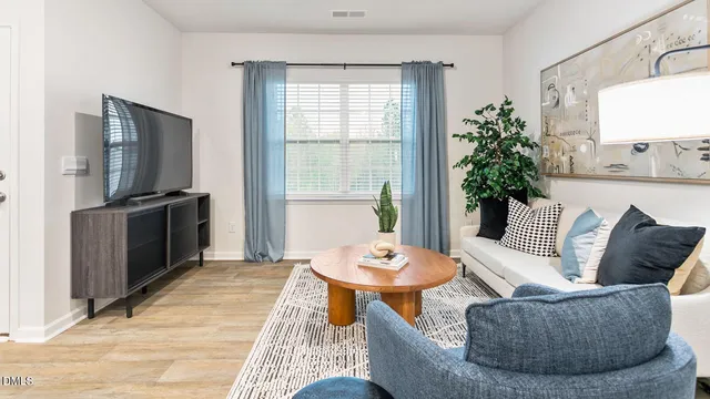 a living room with furniture a flat screen tv and a table