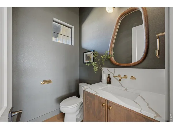 a bathroom with a toilet sink vanity and mirror