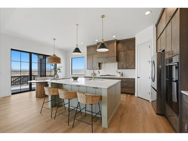 a kitchen with stainless steel appliances kitchen island granite countertop a sink refrigerator and cabinets