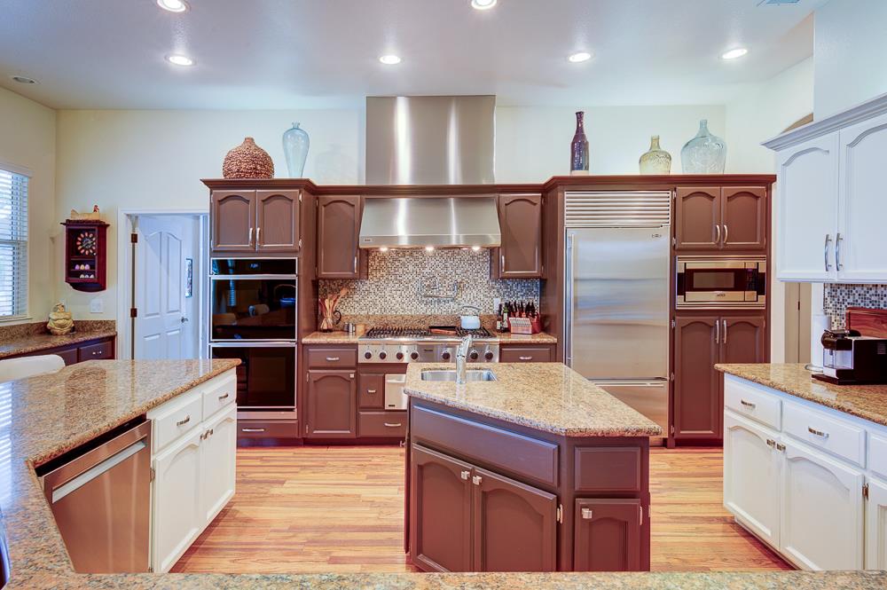 17465 Monreal Road Madera, CA 93636 - Photo 27 of 59 a large kitchen with stainless steel appliances granite countertop a refrigerator and a stove top oven