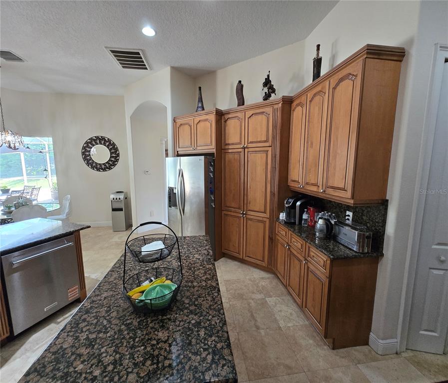 19153 Geraci Road Lutz, FL 33558 - Photo 16 of 21 a kitchen with stainless steel appliances granite countertop a refrigerator and a stove top oven