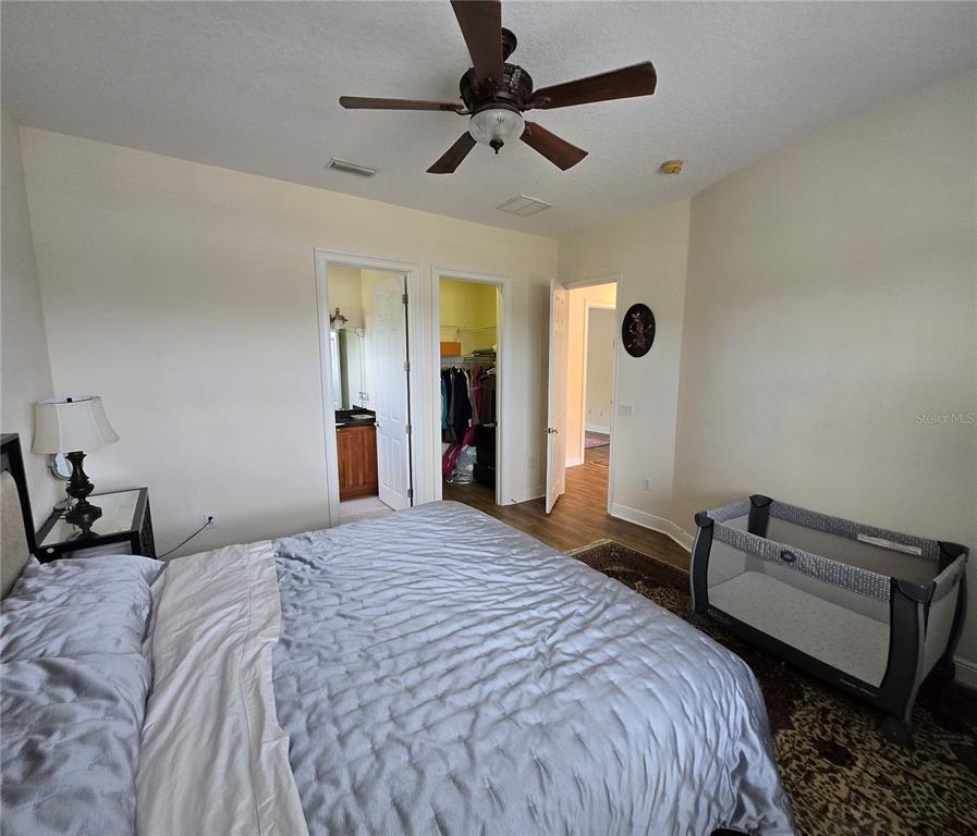 19153 Geraci Road Lutz, FL 33558 - Photo 9 of 21 a bedroom with a bed and a chandelier