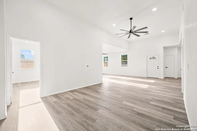 a view of a room with wooden floor and ceiling fan