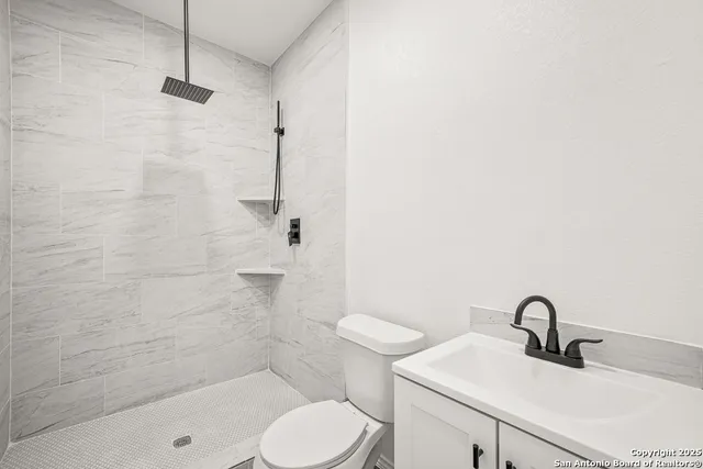 a bathroom with a sink toilet and shower
