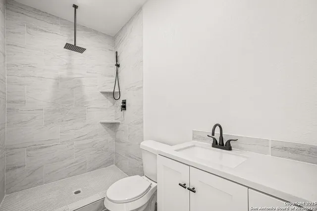 a bathroom with a sink a toilet and shower