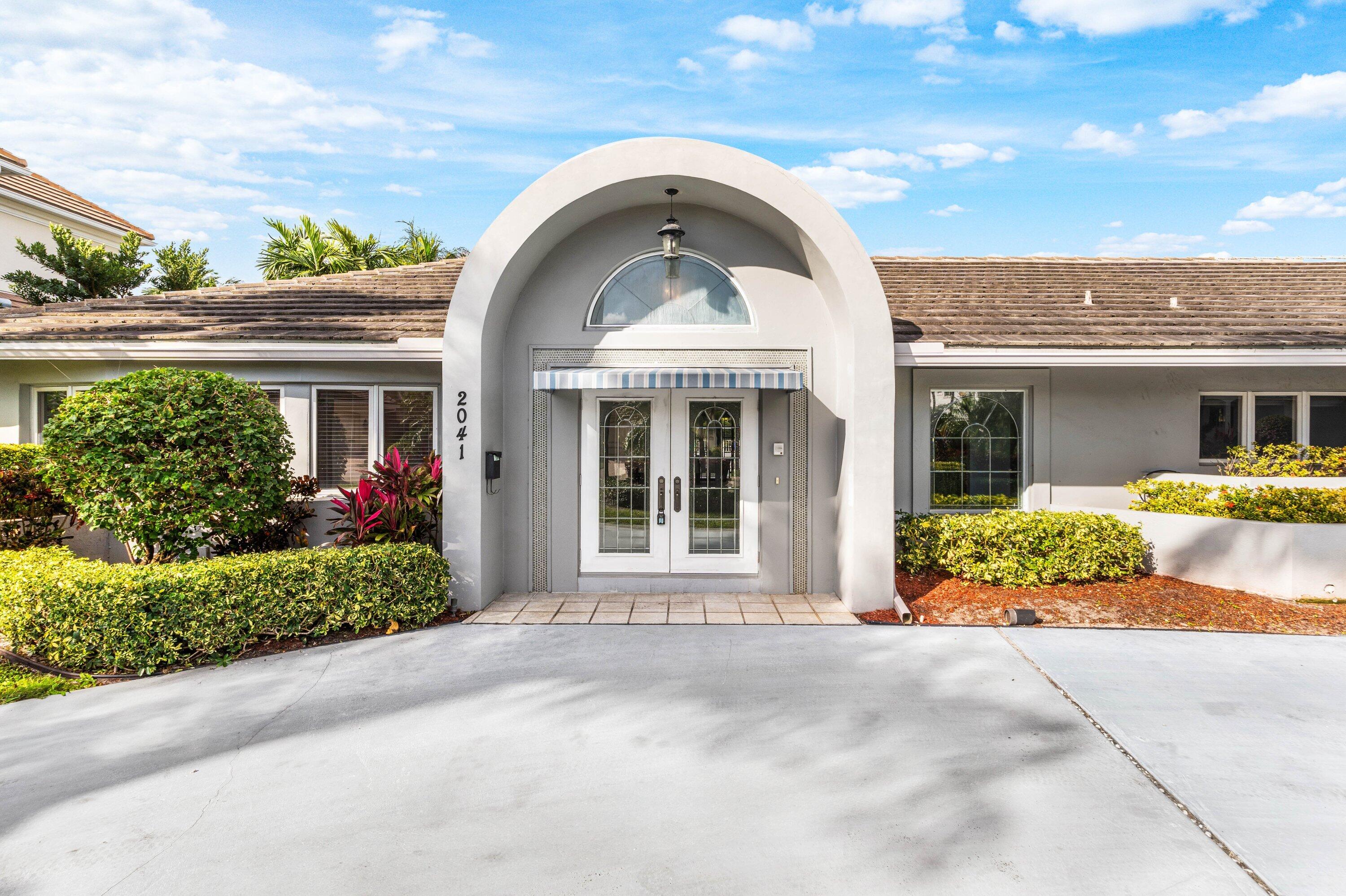 2041 Thatch Palm Drive Boca Raton, FL 33432 - Photo 14 of 45 a front view of a house with a yard