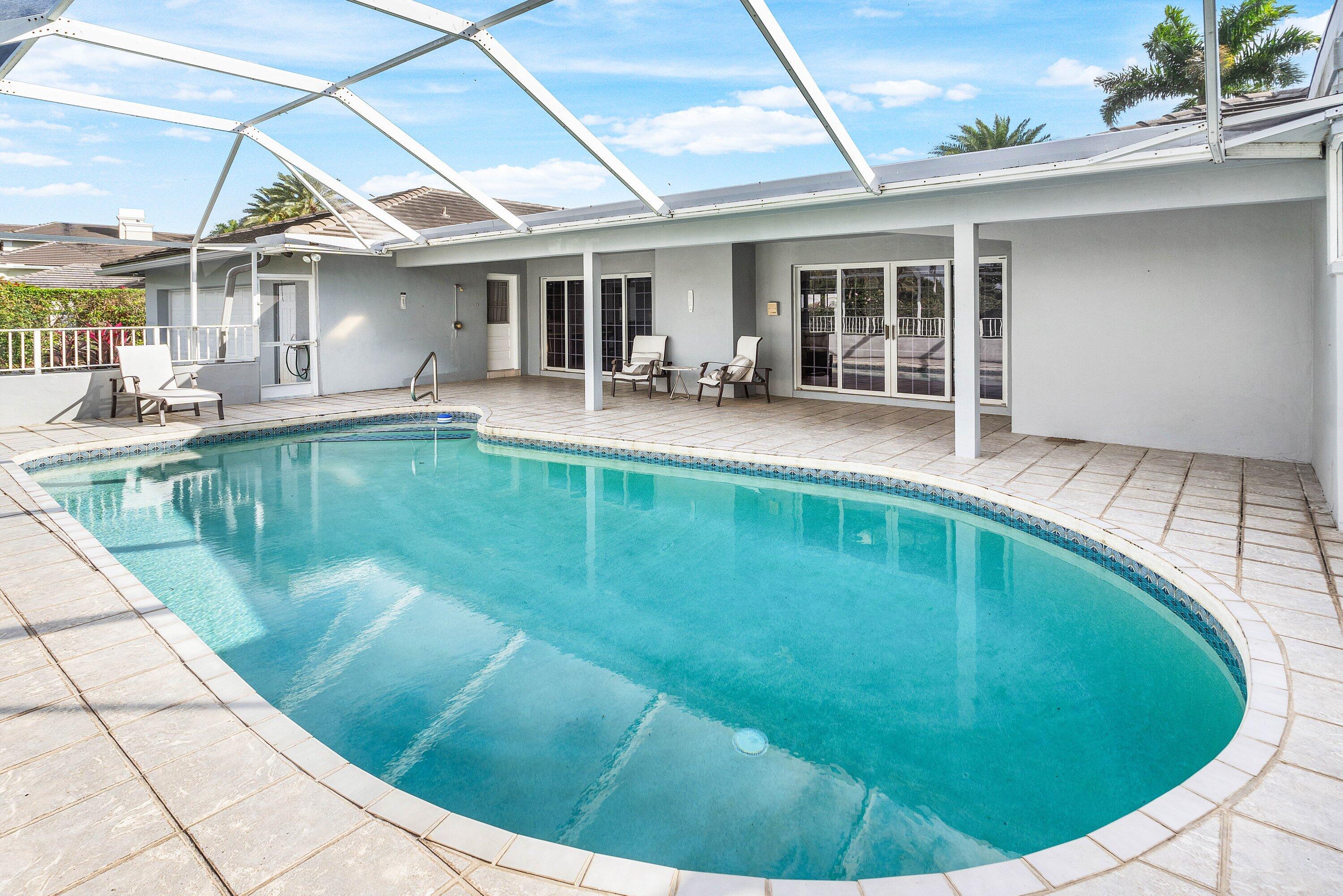 2041 Thatch Palm Drive Boca Raton, FL 33432 - Photo 43 of 45 a view of a patio with dining table and chairs under an umbrella