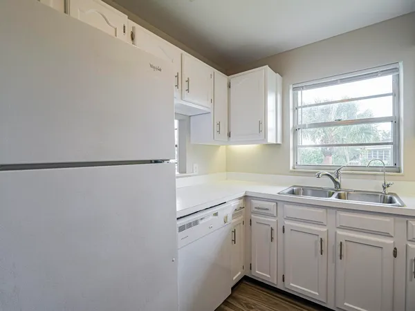a kitchen with a sink a window and cabinets