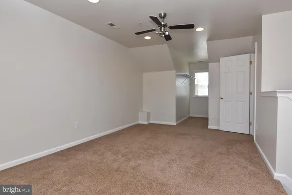 an empty room with closet and a chandelier fan