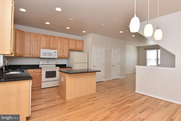 a kitchen with stainless steel appliances granite countertop wooden floors sink and cabinets