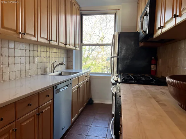a kitchen with granite countertop a stove a sink and a microwave