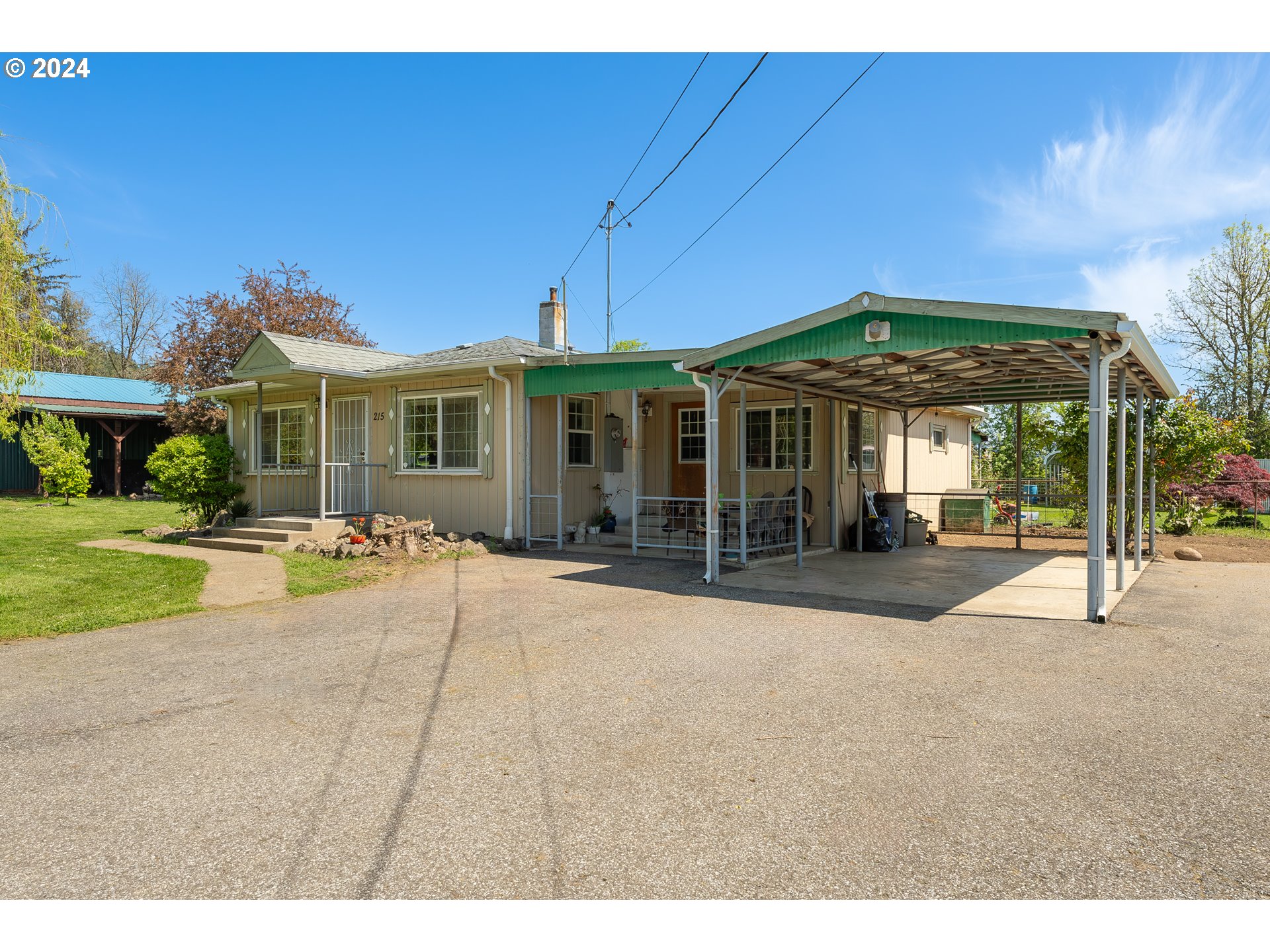 215 Northside Road Sutherlin, OR 97479 - Photo 1 of 40 a patio with a table and chairs under an umbrella