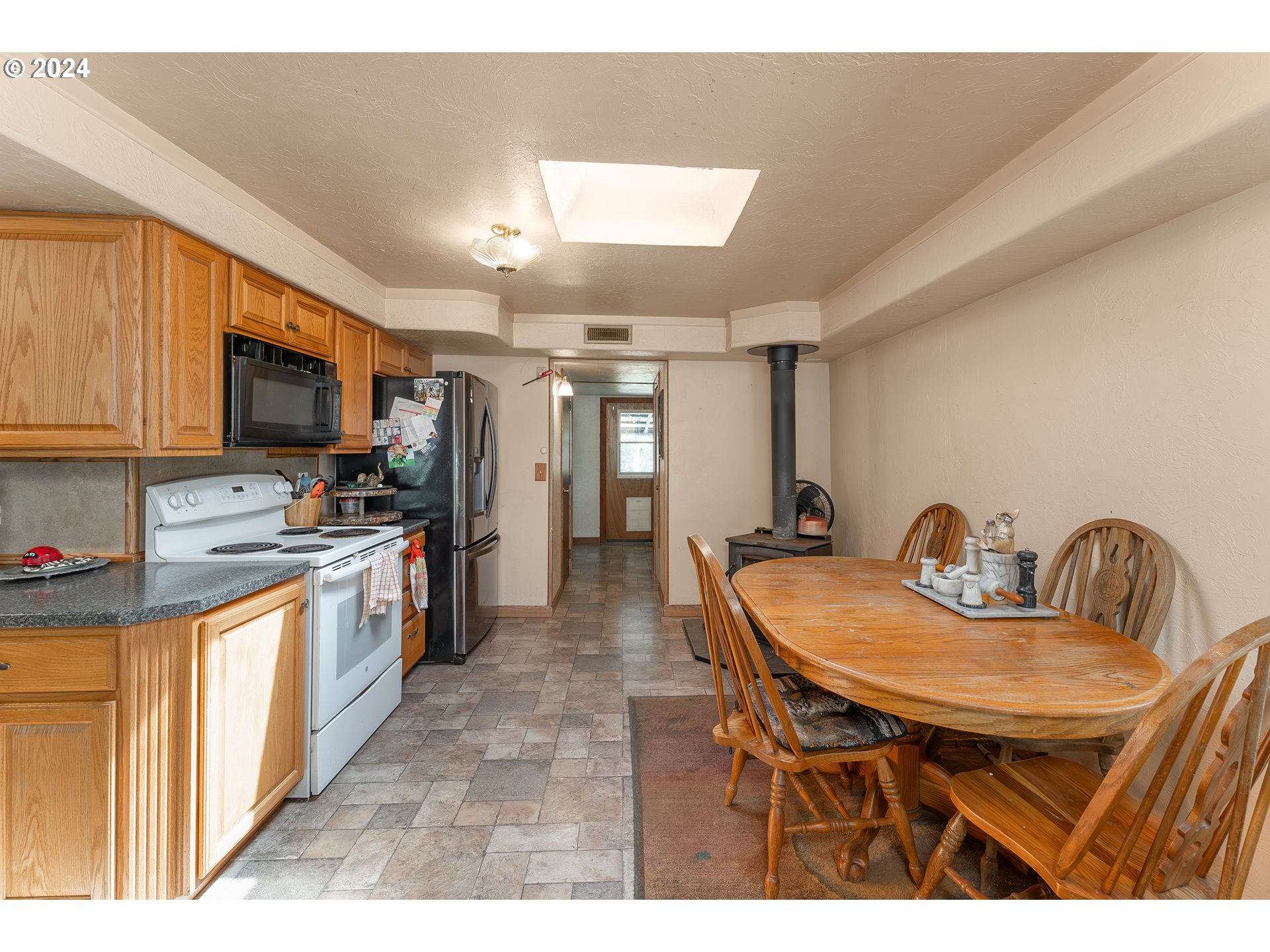 215 Northside Road Sutherlin, OR 97479 - Photo 14 of 40 a kitchen with stainless steel appliances kitchen island granite countertop a table chairs and a refrigerator