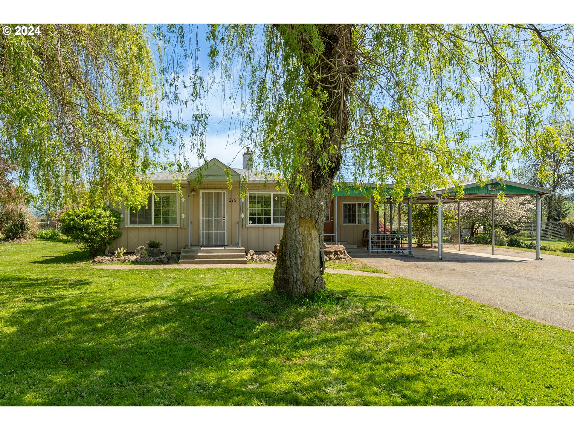 215 Northside Road Sutherlin, OR 97479 - Photo 2 of 40 a view of a house with a big yard and large trees