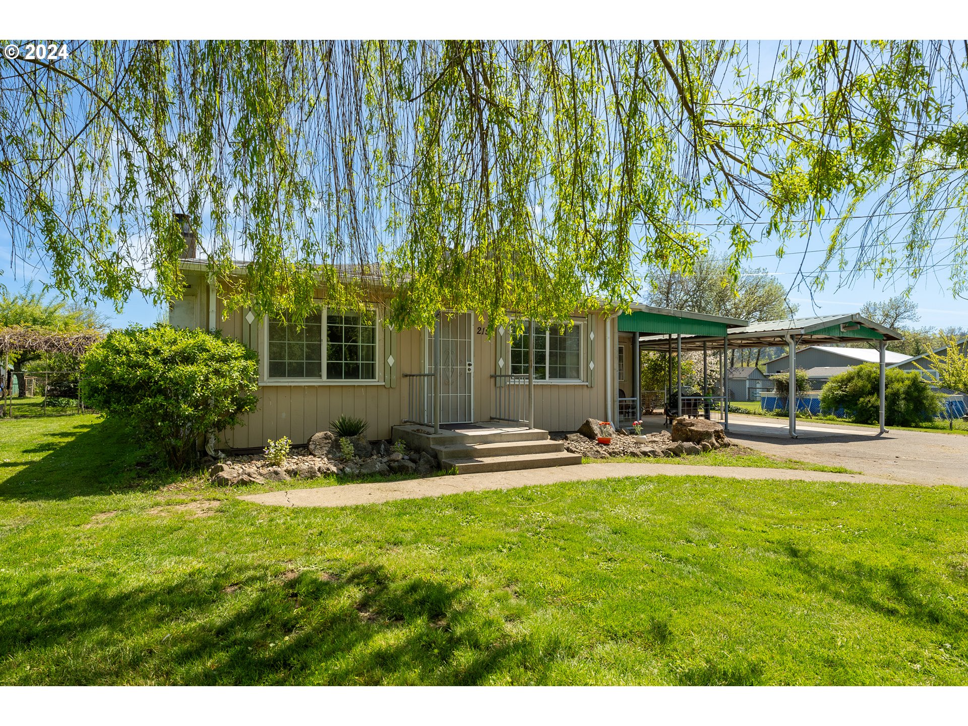 215 Northside Road Sutherlin, OR 97479 - Photo 3 of 40 a view of a swimming pool with lawn chairs and plants