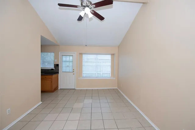an empty room with a window and a fan