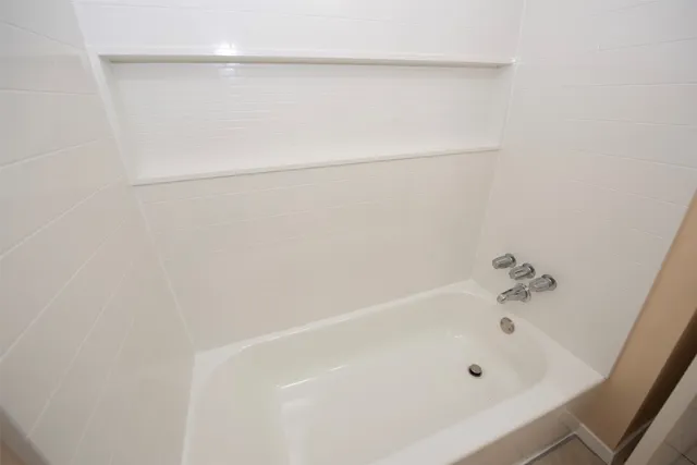 an empty room with a window and a ceiling fan