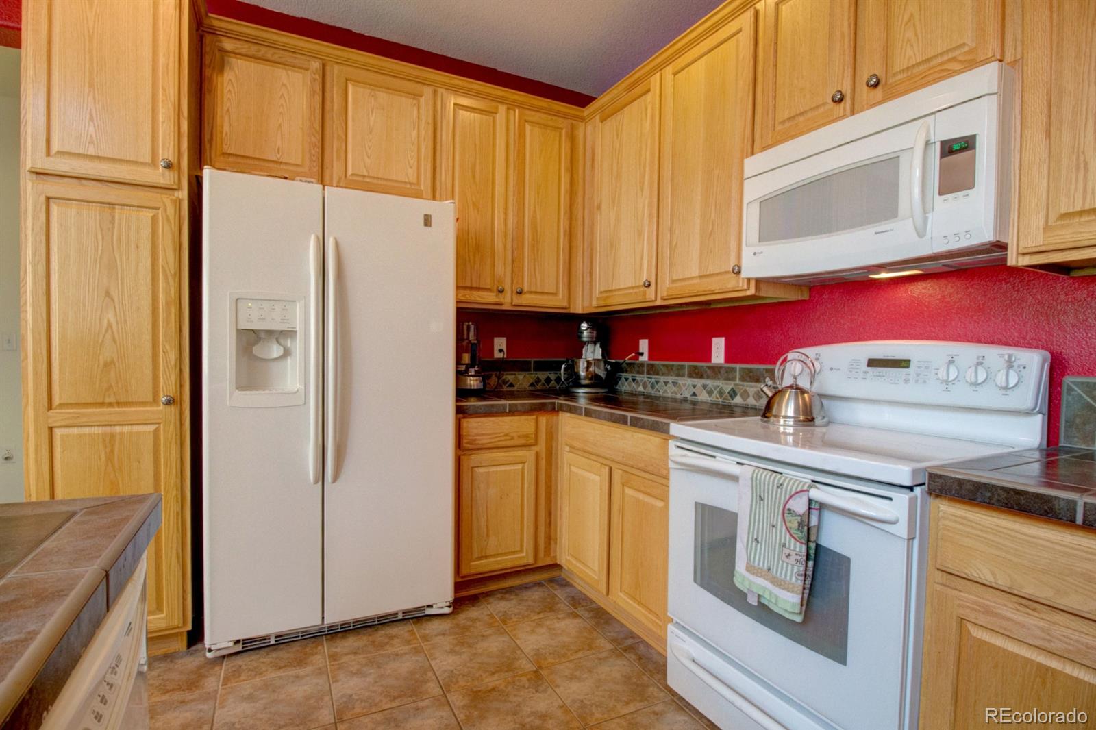 3491 Cascina Place, Unit D Highlands Ranch, CO 80126 - Photo 13 of 22 a kitchen with stainless steel appliances granite countertop a refrigerator a stove and a microwave