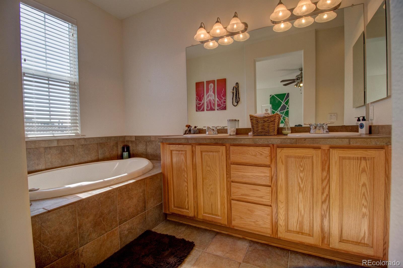 3491 Cascina Place, Unit D Highlands Ranch, CO 80126 - Photo 15 of 22 a bathroom with a double vanity sink and a bathtub