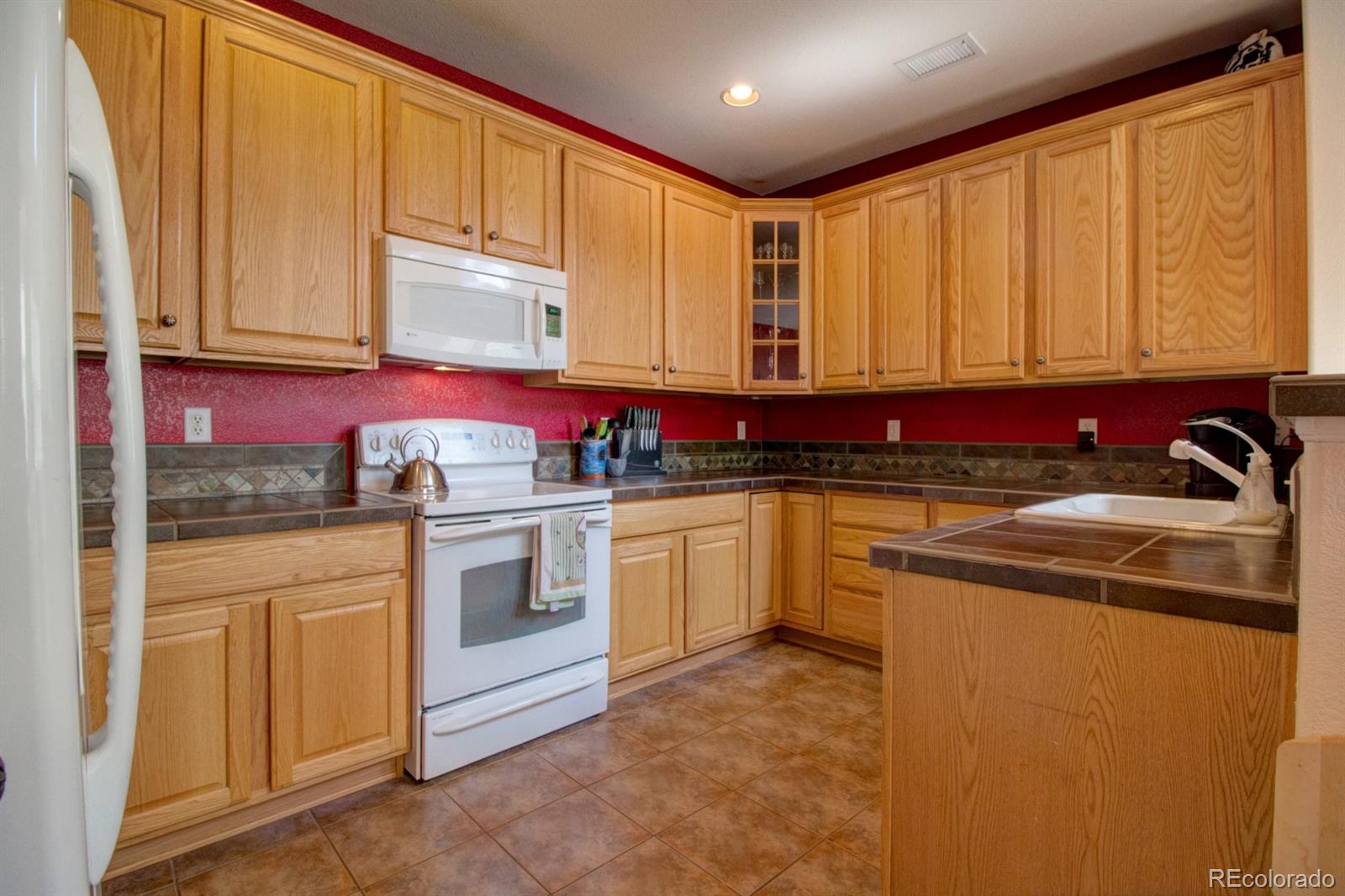 3491 Cascina Place, Unit D Highlands Ranch, CO 80126 - Photo 4 of 22 a kitchen with stainless steel appliances granite countertop a stove a sink and a microwave