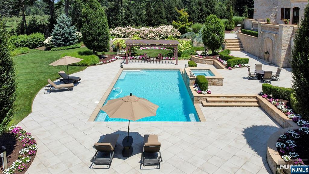 123 East Saddle River Road Saddle River, NJ 07458 - Photo 11 of 50 a view of a swimming pool with a patio and a garden