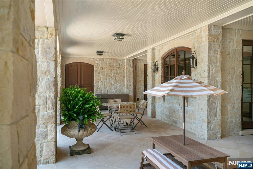 123 East Saddle River Road Saddle River, NJ 07458 - Photo 23 of 50 a view of a patio with a table and chairs under an umbrella