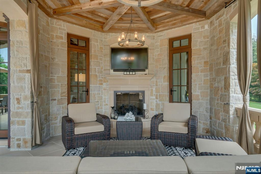 123 East Saddle River Road Saddle River, NJ 07458 - Photo 26 of 50 a living room with furniture a flat screen tv and a fireplace