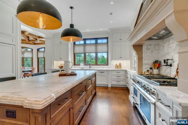 a kitchen with stainless steel appliances granite countertop a stove a sink and a wooden floors