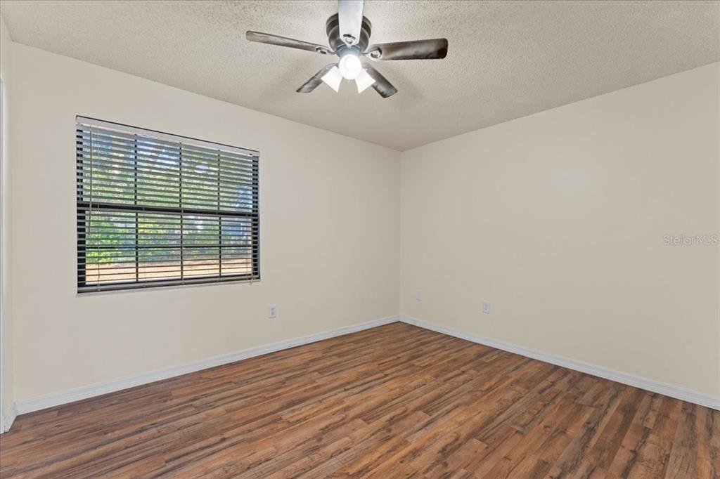 3701 Modesto Street New Port Richey, FL 34655 - Photo 14 of 41 a view of a room with wooden floor and a ceiling fan