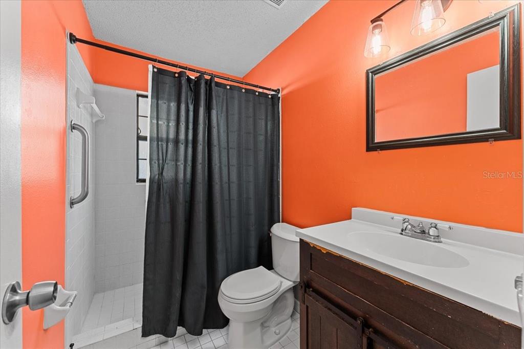 3701 Modesto Street New Port Richey, FL 34655 - Photo 18 of 41 a bathroom with a sink a toilet and shower curtain