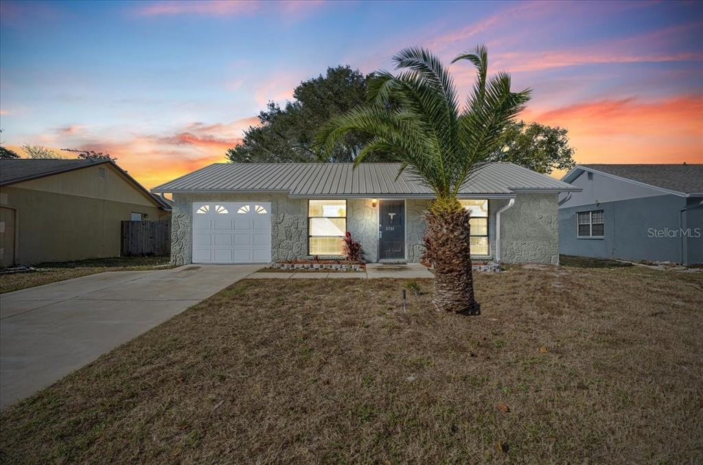 3701 Modesto Street New Port Richey, FL 34655 - Photo 2 of 41 a view of a house with a yard and garage