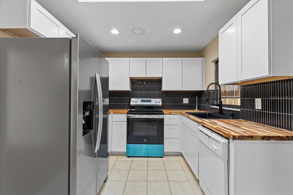 3701 Modesto Street New Port Richey, FL 34655 - Photo 7 of 41 a kitchen with granite countertop a refrigerator and a stove top oven