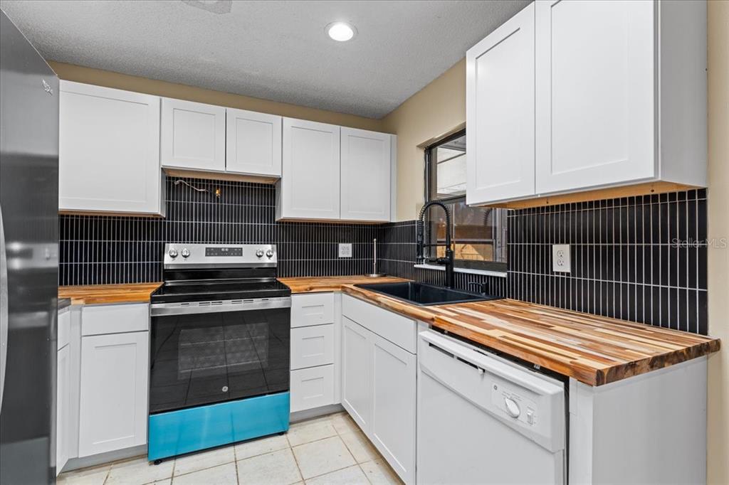 3701 Modesto Street New Port Richey, FL 34655 - Photo 8 of 41 a kitchen with stainless steel appliances granite countertop a stove a sink and a microwave