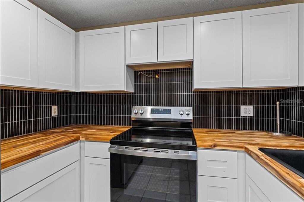 3701 Modesto Street New Port Richey, FL 34655 - Photo 9 of 41 a kitchen with granite countertop a stove sink and cabinets