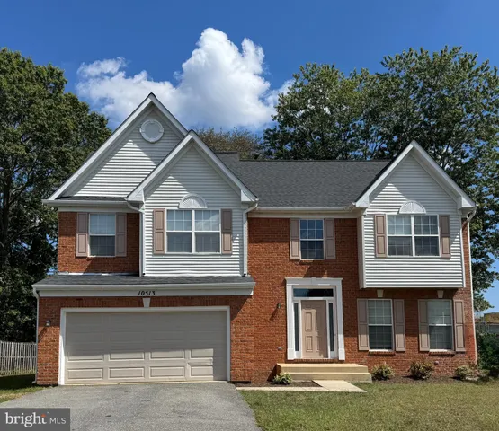 a front view of a house with a garden and yard