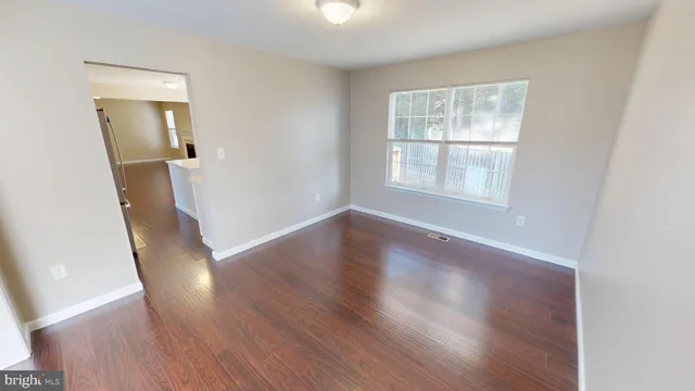 a view of empty room with wooden floor and fireplace