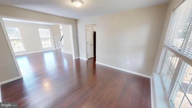 a view of empty room with wooden floor and fireplace